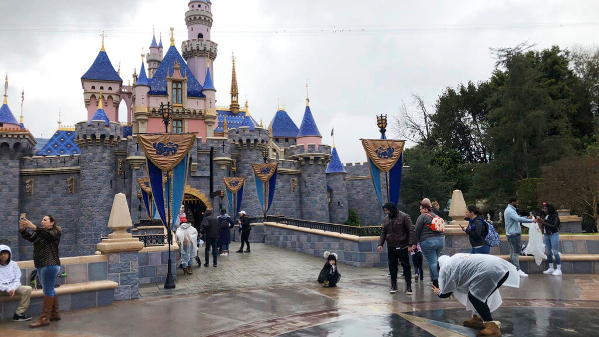 FILE: Visitors take photos at Disneyland in Anaheim, Calif. 