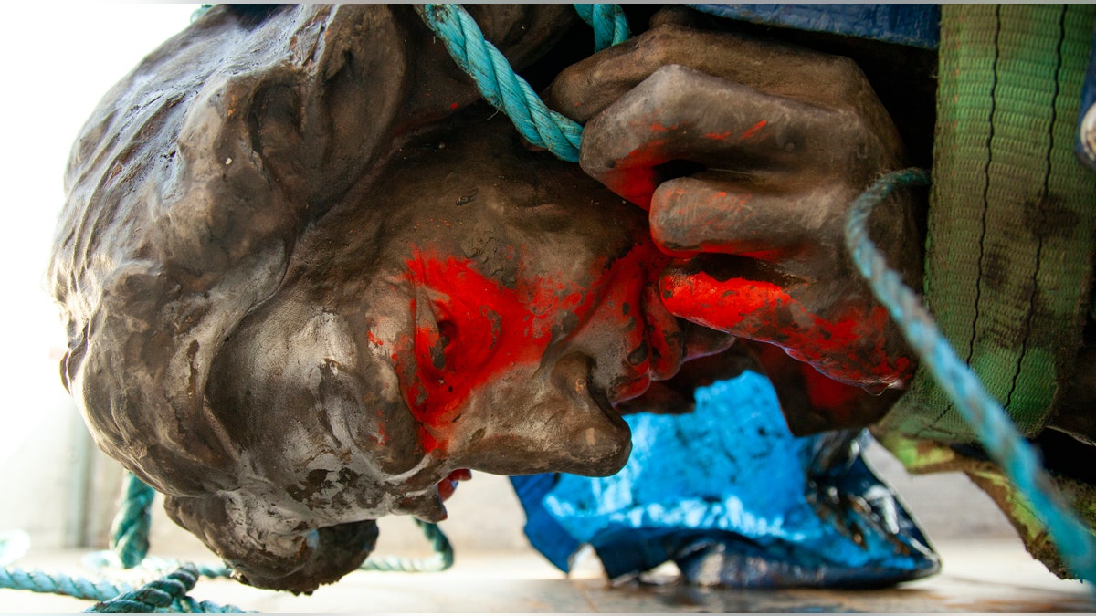 In this photograph made available by Bristol City Council, the statue of Edward Colston is placed in the back of a truck after being recovered from the harbour in Bristol, Thursday June 11, 2020, after it was toppled by anti-racism protesters on Sunday. (Bristol City Council via AP)