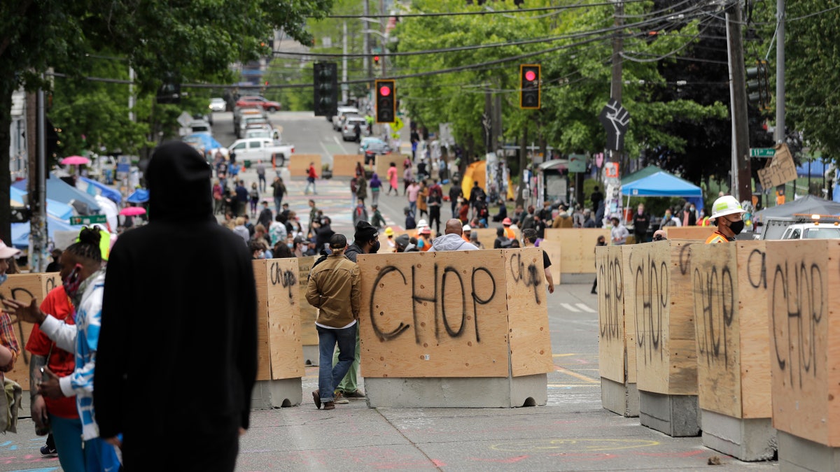New cement and wood barricades bear the name CHOP, Tuesday, June 16, 2020, inside what has been named the Capitol Hill Occupied Protest zone in Seattle. The city put the barriers in place Tuesday in hopes of defining an area where emergency, delivery, and other vehicles can travel through the area while still preserving space for protesters, who have been there since police pulled back from near the department's East Precinct after recent clashes with people protesting the death of George Floyd.