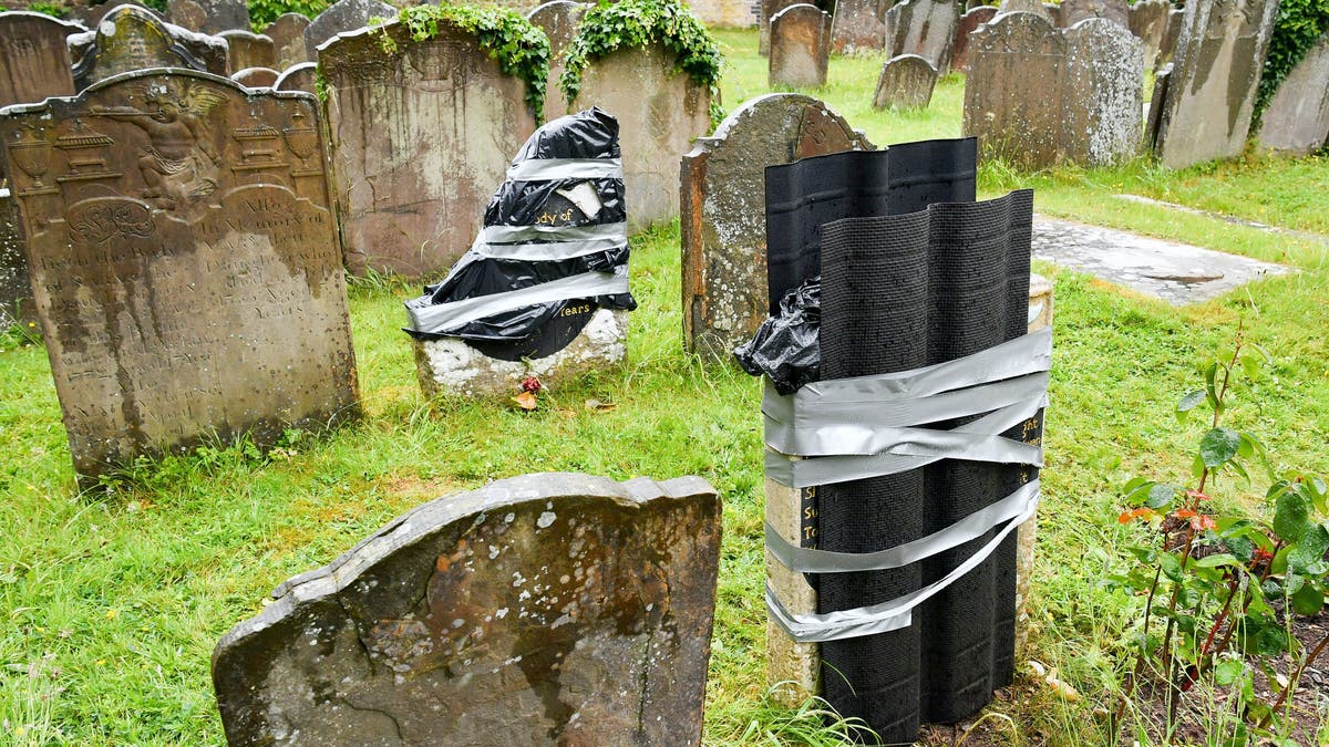 The damaged headstone and footstone on the grave of an enslaved African man, in St Mary's churchyard, in Bristol, England, Thursday June 18, 2020, which have been vandalized in an apparent "retaliation attack" following the toppling of a statue of slave trader Edward Colston during anti-racist protests held in the wake of the killing of George Floyd in the US. The Grade II-listed, brightly painted memorial to Scipio Africanus have been smashed and a message was scrawled in chalk on flagstones nearby. (Ben Birchall/PA via AP)