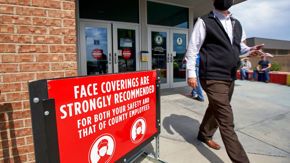 A man wearing a face mask exits the Sarpy County administration building in Papillion, Neb., on Thursday, June 18, 2020, where face covering is recommended but not mandatory. (AP Photo/Nati Harnik)