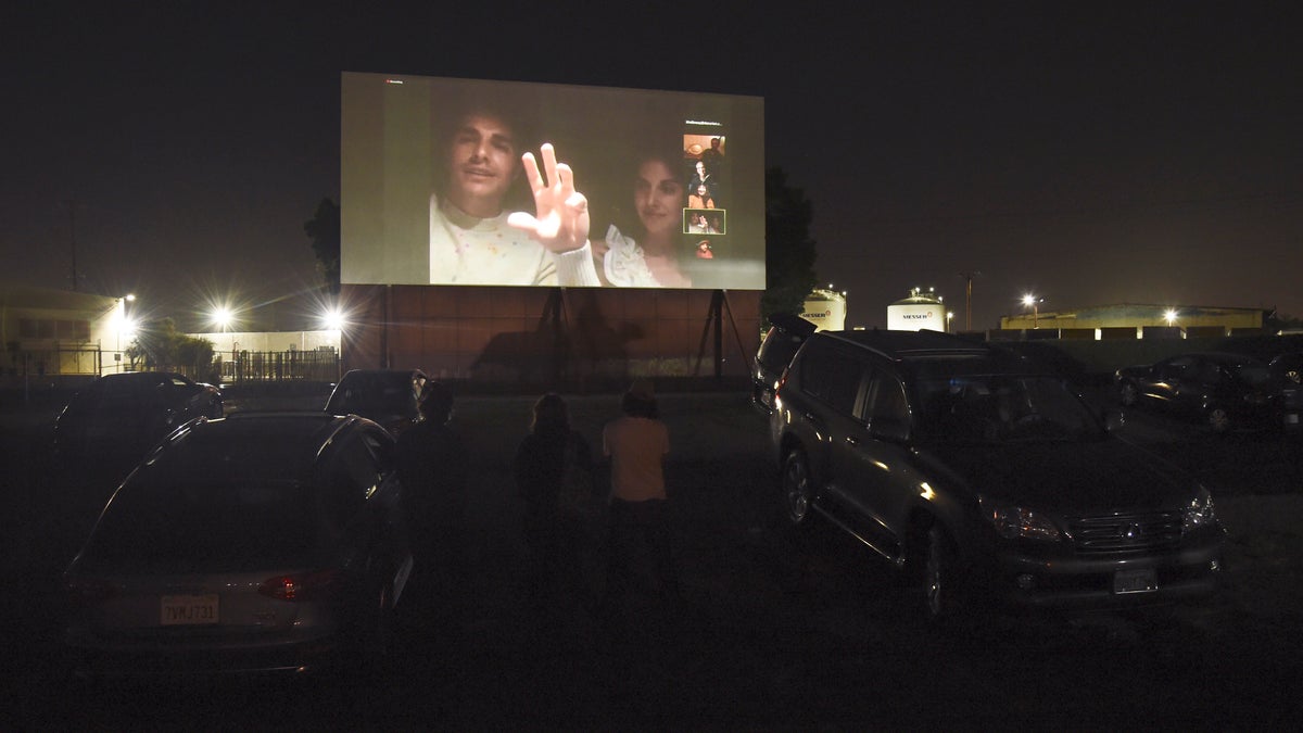 Dave Franco, left, director/co-writer of "The Rental," and his wife, cast member Alison Brie, are seen on a movie screen as they take part in a Zoom Q&A session from their car following an advance screening of the film at the Vineland Drive-In, Thursday, June 18, 2020, in City of Industry, Calif. (AP Photo/Chris Pizzello)