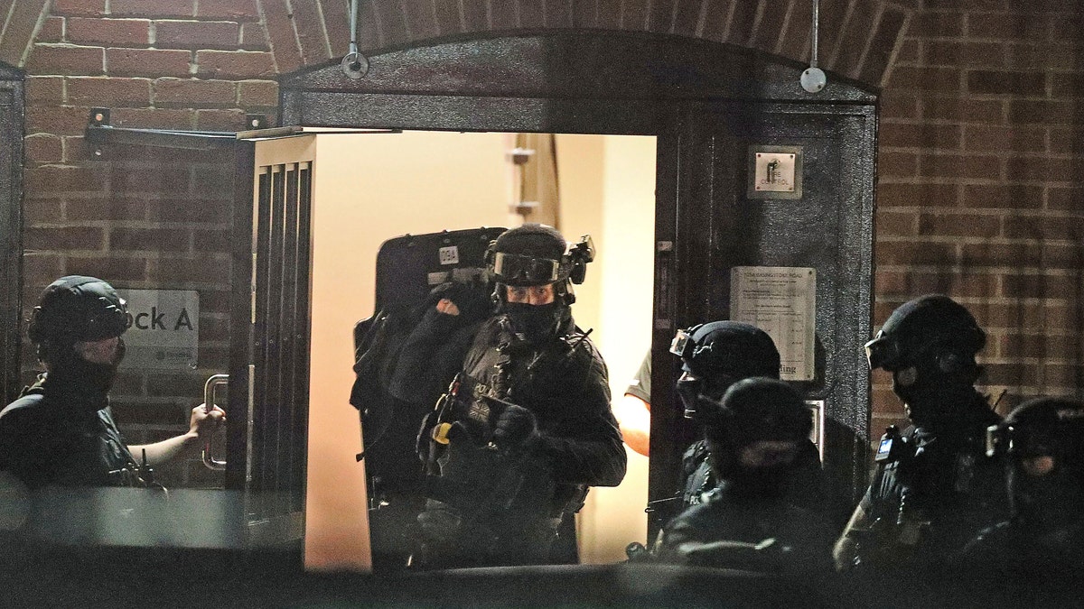 Armed police officers work at a block of flats off Basingstoke Road in Reading after an incident at Forbury Gardens park in the town centre of Reading, England, Saturday, June 20, 2020. Several people were injured in a stabbing attack in the park on Saturday, and British media said police were treating it as “terrorism-related.” (Steve Parsons/PA via AP)