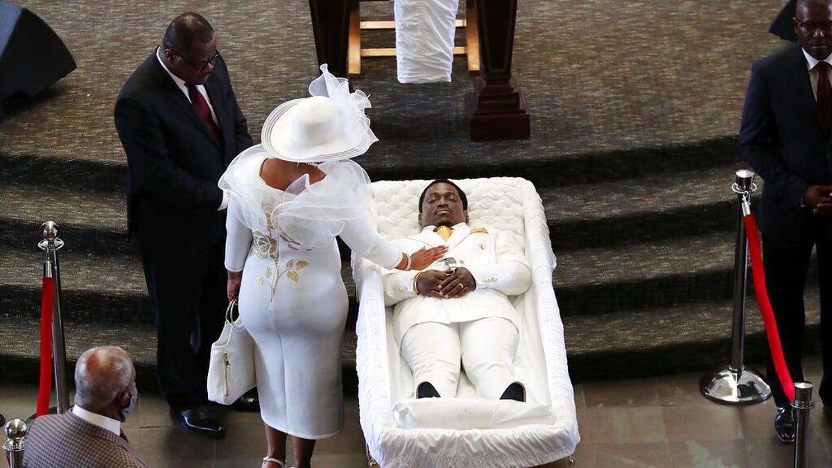 Tomika Miller, the wife of Rayshard Brooks, touches her husband during a family visit just before a public viewing begins at Ebenezer Baptist Church on Monday, Jun 22, 2020 in Atlanta. 