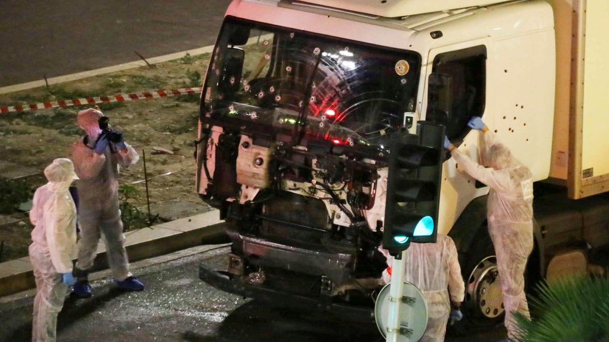 Authorities investigate a truck after it plowed through Bastille Day revellers in the French resort city of Nice, southern France, on July 14, 2016. France's counterterrorism prosecutors have requested nine suspects to be sent to trial in connection with the attack in Nice that left 86 people dead.<br>
(Sasha Goldsmith via AP, File)