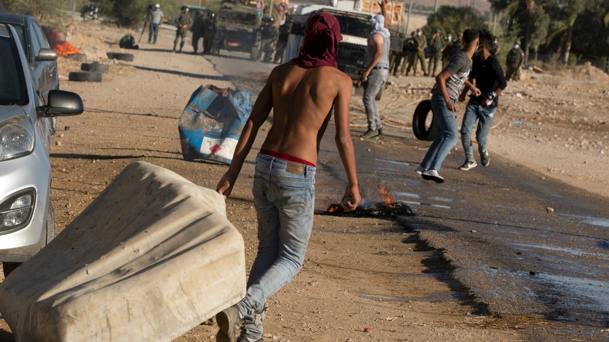 Palestinian demonstrators clash with the Israeli troops during a protest against Israel's plan to annex parts of the West Bank and Trump's Middle East initiative, at the village of Fasayil, in Jordan Valley, Wednesday, Jun. 24, 2020. (AP Photo/Majdi Mohammed)