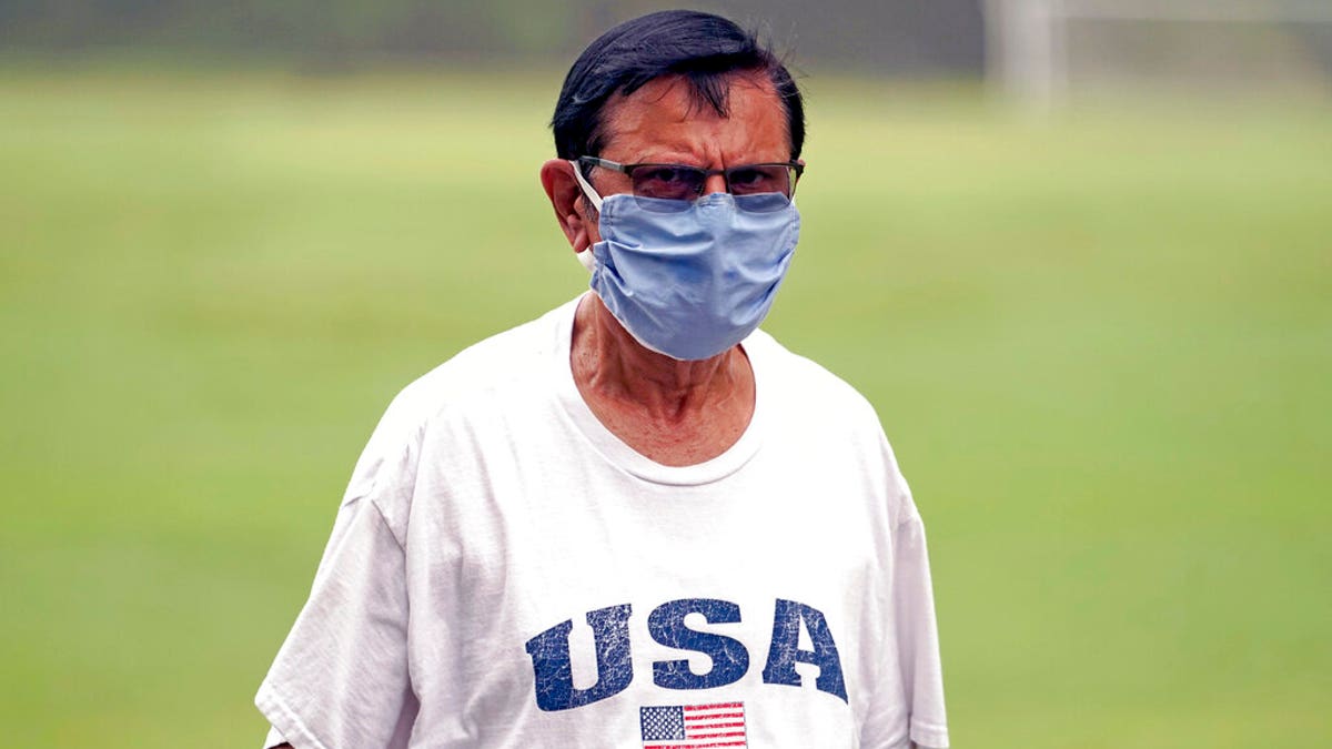 Shiraz Merchant wears a mask as he walks in a park Friday, June 26, 2020, in Houston. The number of COVID-19 cases continues to rise across the state. Texas Gov. Greg Abbott has said that the state is facing a "massive outbreak" in the coronavirus pandemic and that some new local restrictions may be needed to protect hospital space for new patients. (AP Photo/David J. Phillip)