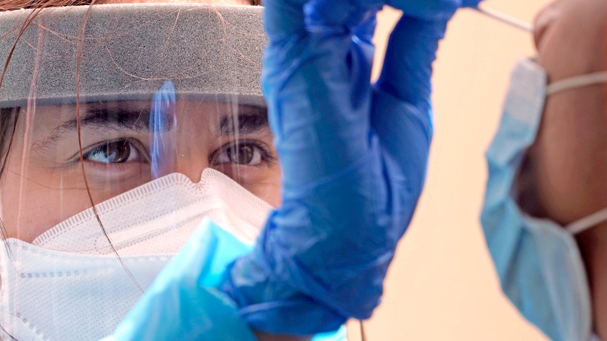 Medical student Kimberly Olivares, left, takes a sample from a patient at a free COVID-19 testing site provided by United Memorial Medical Center, Sunday, June 28, 2020, at the Mexican Consulate, in Houston. Confirmed cases of the coronavirus in Texas continue to surge. On Friday, Texas Gov. Greg Abbott shut down bars again and scaled back restaurant dining as cases climbed to record levels after the state embarked on one of America's fastest reopenings.