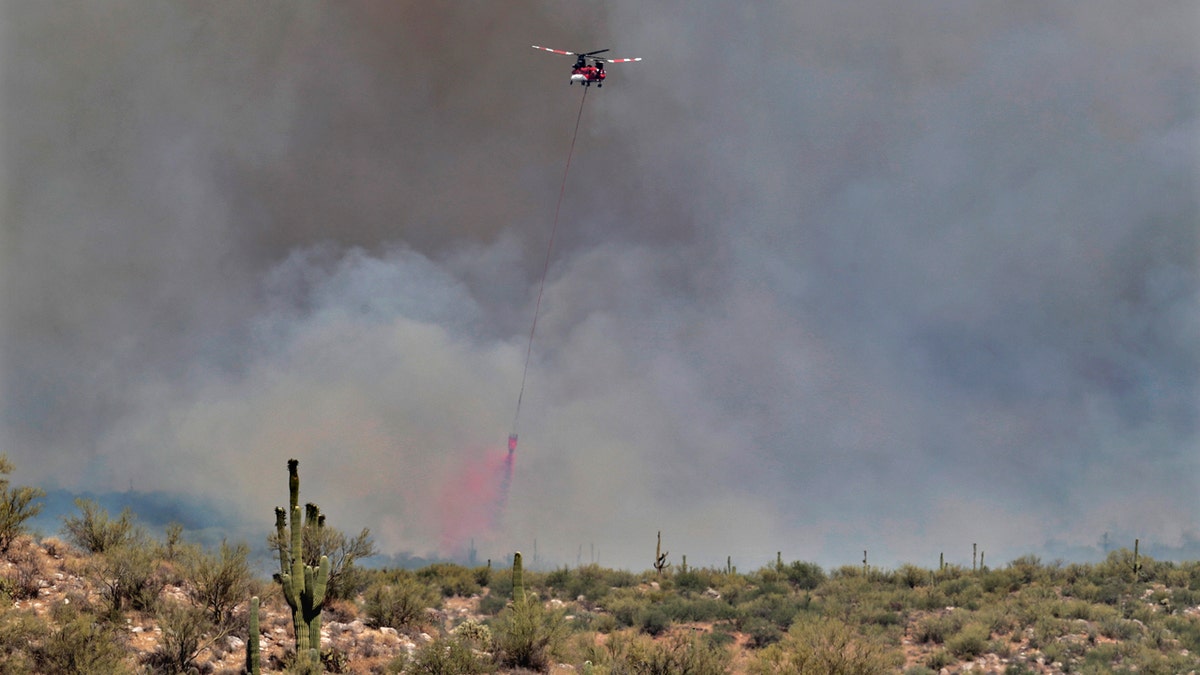 A wildfire air attack crew crew douses the Sonoran Desert filled with saguaro cacti with retardant during the Bighorn Fire Friday, June 12, 2020, in Oro Valley, Ariz.