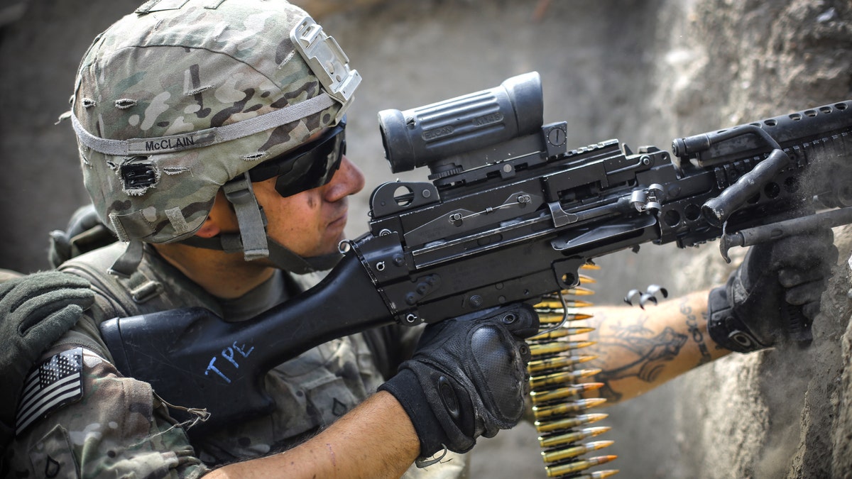 A US soldier from 2-12 Infantry Regiment out of Colorado Springs fires a machine gun at insurgent positions during a firefight on June 22, 2012 in the Pech Valley, Afghanistan - file photo.