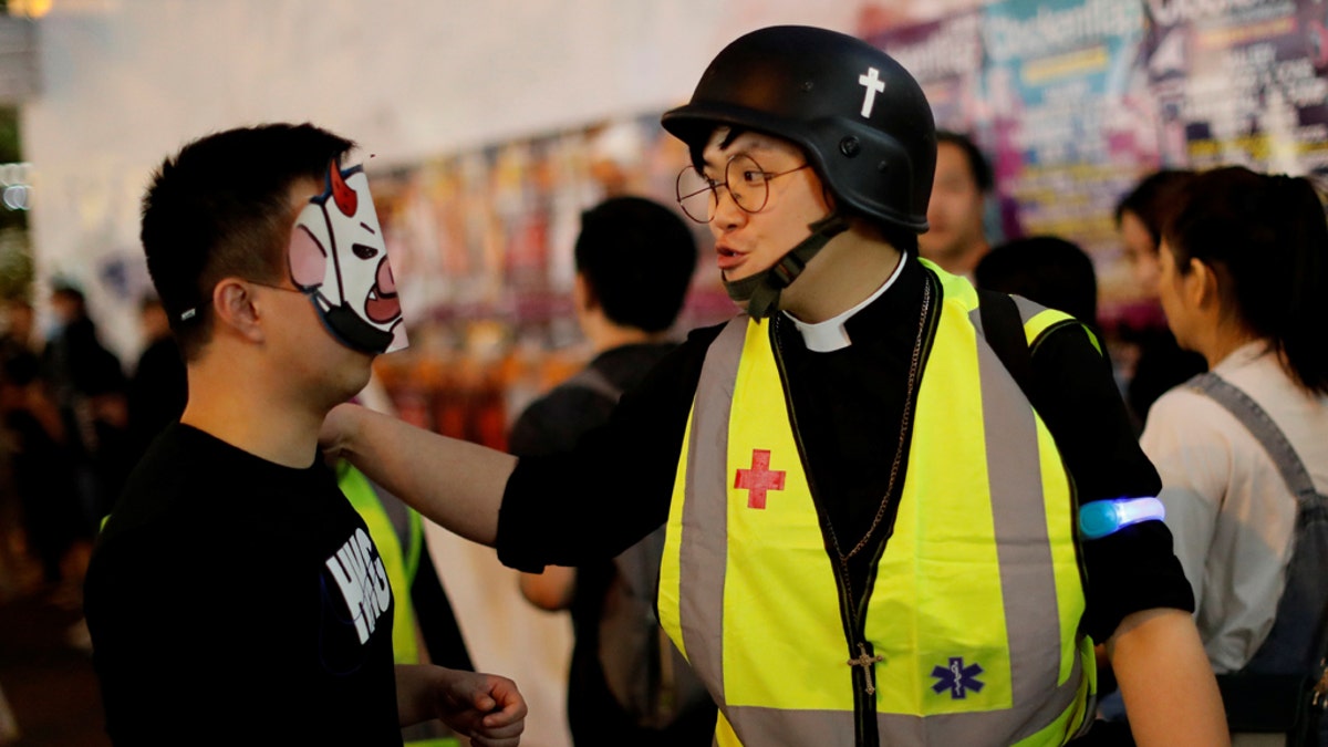 Pastor Alan Keung talks with a protester wearing a Halloween mask during an anti-government protest on Halloween in Hong Kong, China October 2019. (REUTERS/Kim Kyung-Hoon)