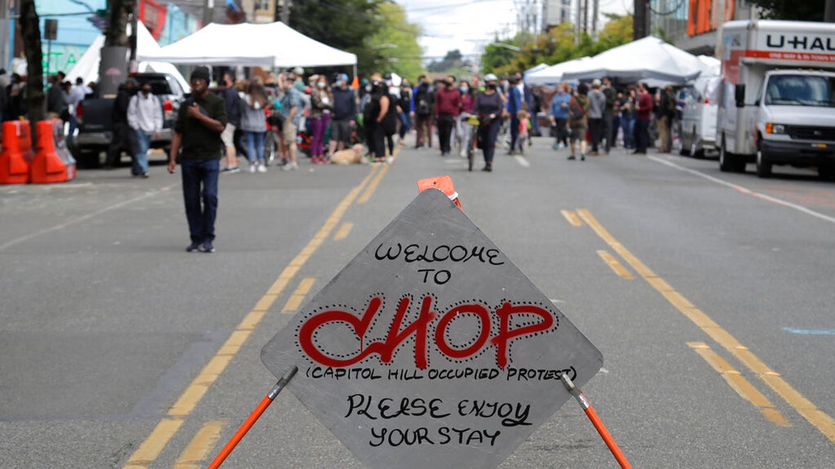 A sign reads "Welcome to CHOP," Sunday, June 14, 2020, inside what has been named the Capitol Hill Occupied Protest zone in Seattle. Protesters calling for police reform and other demands have taken over several blocks near downtown Seattle after officers withdrew from a police station in the area following violent confrontations. The CHOP name is a change from CHAZ (Capitol Hill Autonomous Zone) that was used earlier in the week. (AP Photo/Ted S. Warren)