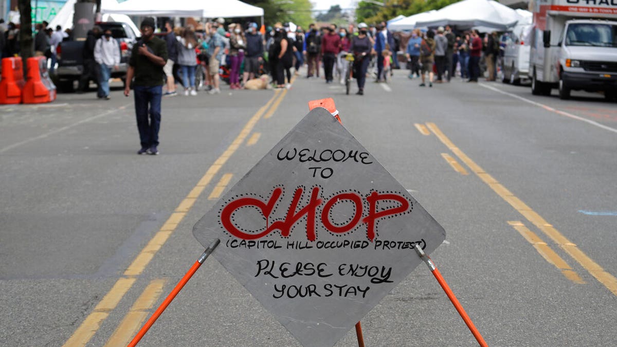 A sign reads "Welcome to CHOP," Sunday, June 14, 2020, inside what has been named the Capitol Hill Occupied Protest zone in Seattle. Protesters calling for police reform and other demands have taken over several blocks near downtown Seattle after officers withdrew from a police station in the area following violent confrontations. The CHOP name is a change from CHAZ (Capitol Hill Autonomous Zone) that was used earlier in the week. (AP Photo/Ted S. Warren)