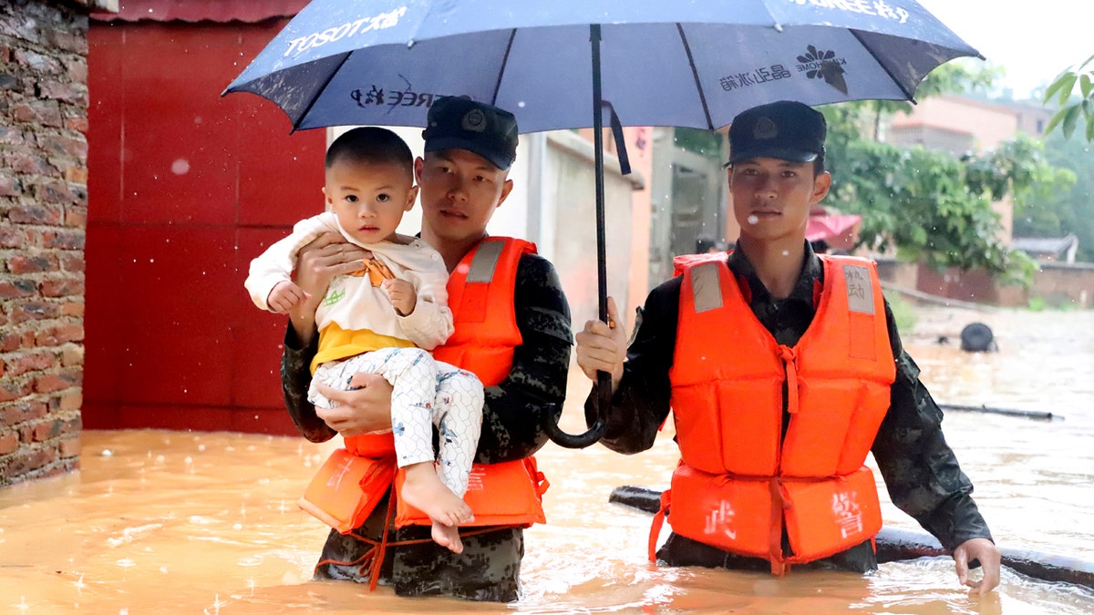 Rescuers carry a child to a boat during an evacuation of a flooded village in Qingyuan in southern China's Guangdong province on June 8.