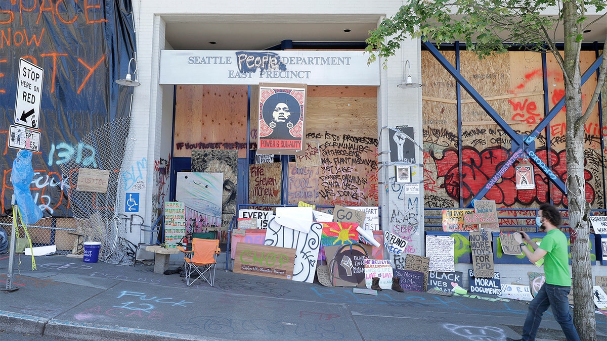 A person takes a photo of the Seattle Police East Precinct building, Monday, June 22, 2020, inside what has been named the Capitol Hill Occupied Protest zone in Seattle. (AP Photo/Ted S. Warren)