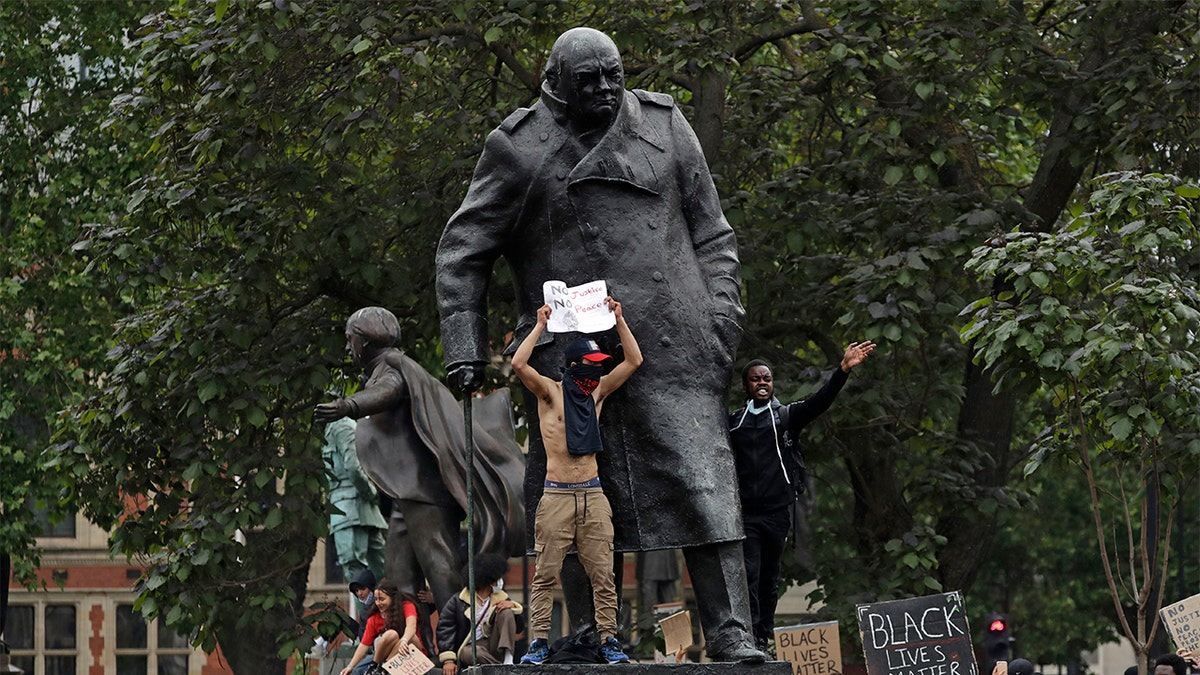 Protesters stand on the statue of former British Prime Minister Winston Churchill during a demonstration in Parliament Square in London earlier this week