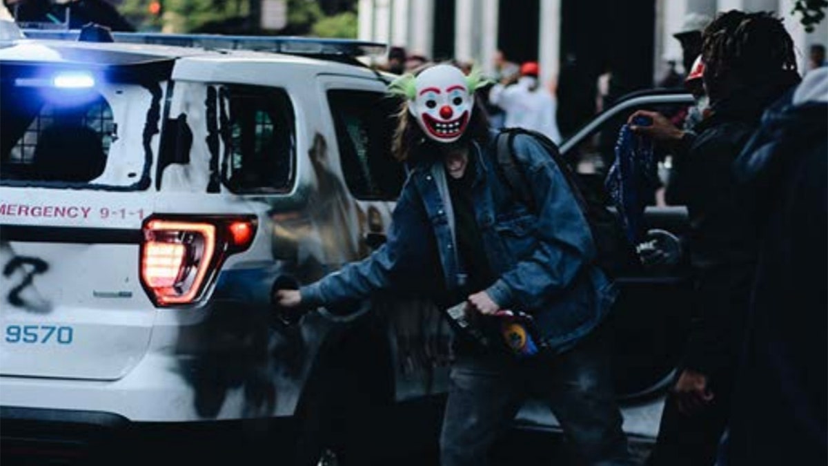 Photos of the scene show a man in a mask, similar to ones used in the 2019 “Joker” movie, a "Batman" spinoff that depicts citywide rioting leading up to its final scene. (Courtesy: DOJ)