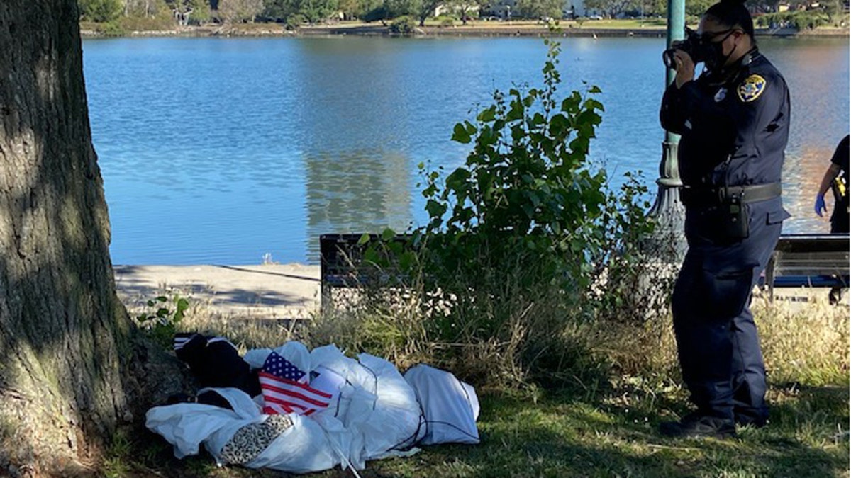 When officers and a supervisor arrived at the scene, they found “material stuffed in the shape of a human body with a rope tied around the torso and neck, laying on the ground next to a tree with an American flag lying next to it.”