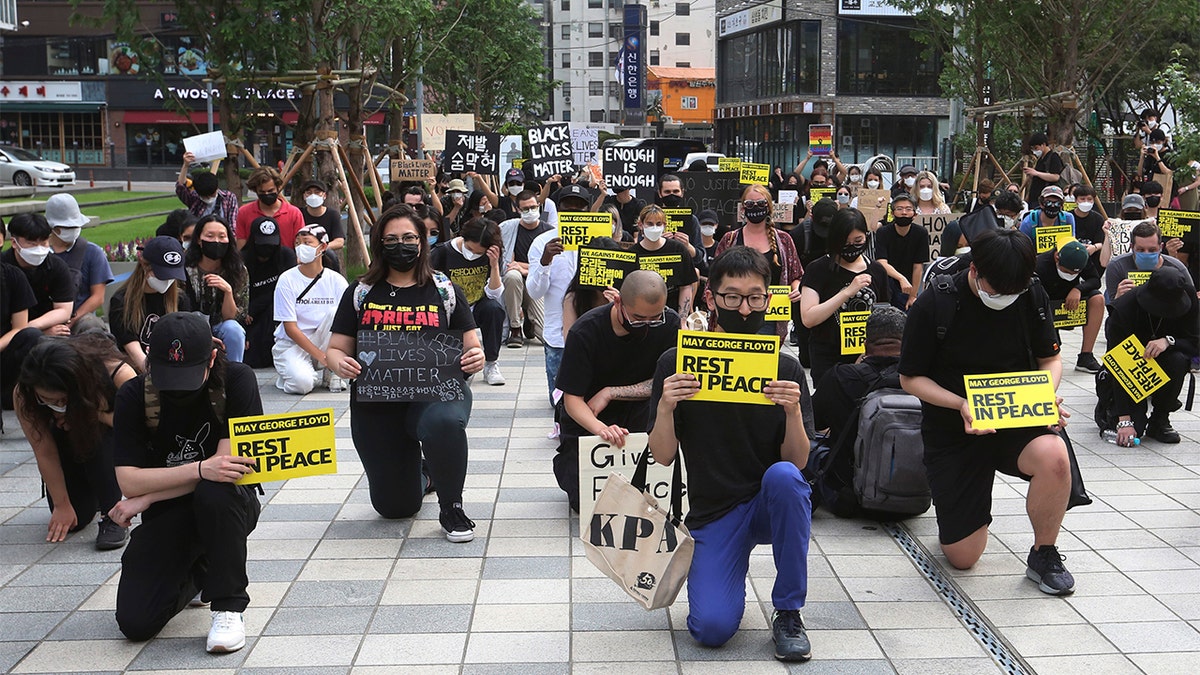 People kneel to protest during a solidarity rally for the death of George Floyd in Seoul, South Korea, Saturday, June 6, 2020. Floyd died after being restrained by Minneapolis police officers on May 25.(AP Photo/Ahn Young-joon)