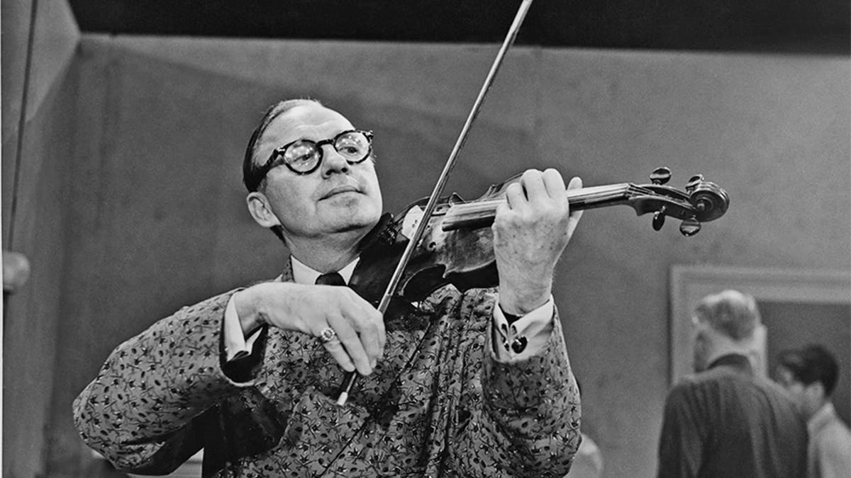 American comedian and actor Jack Benny (1894 - 1974) playing the violin, circa 1950s.