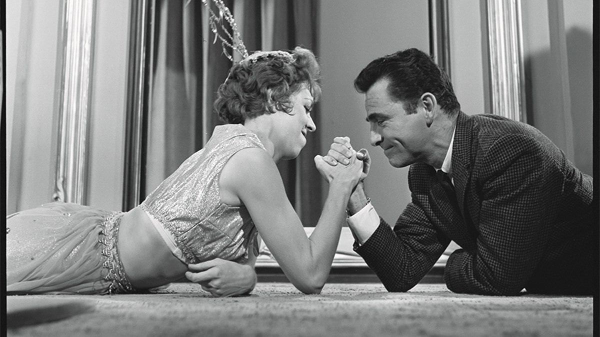 In an off-camera moment, Rod Serling arm wrestles with Carol Burnett.