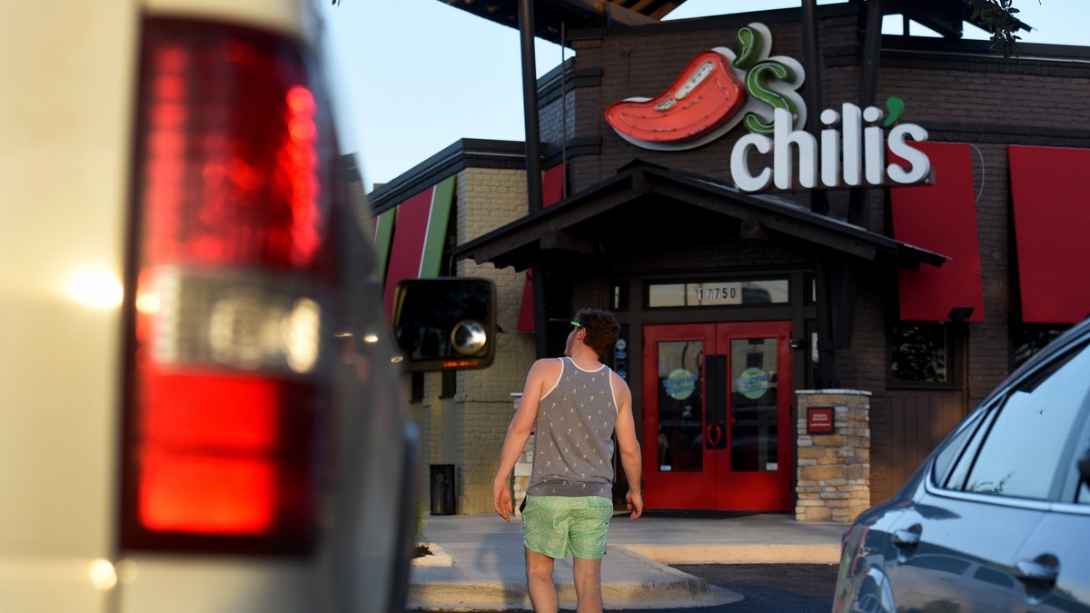 In this file photo, a customer walks towards the entrance of a Chili's Grill &amp; Bar restaurant in San Antonio, Texas.