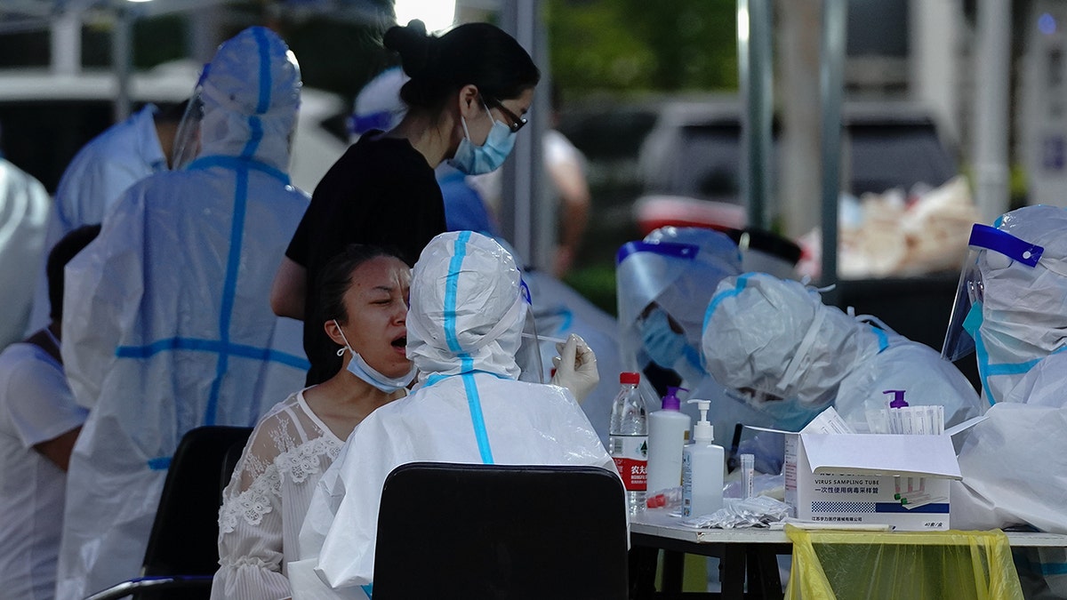  A medical worker wearing a protective suit takes a swap at a temporary COVID-19 testing site on June 28, 2020 in Beijing, China. (Photo by Lintao Zhang/Getty Images)