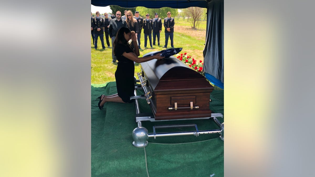 Robinson passed away in May due to his illness. Wife Danielle Robinson is seen here during his burial ceremony.