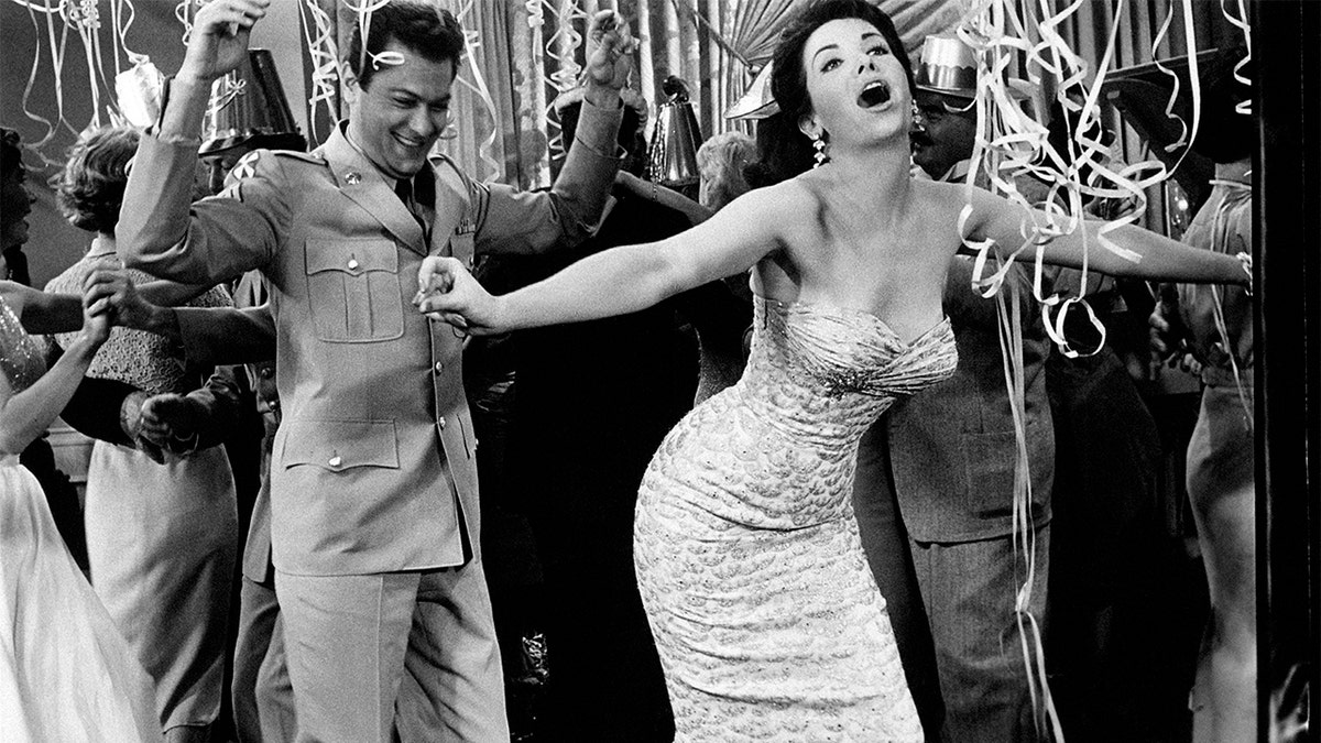 Argentine-American actress Linda Cristal, born Maria Victoria Moya Burges, goes wild at a party with American actor Tony Curtis, born Bernard Schwartz, in a scene from the movie, 'The Perfect Furlough,' by American director Blake Edwards. 1959. (Photo by Mondadori via Getty Images)