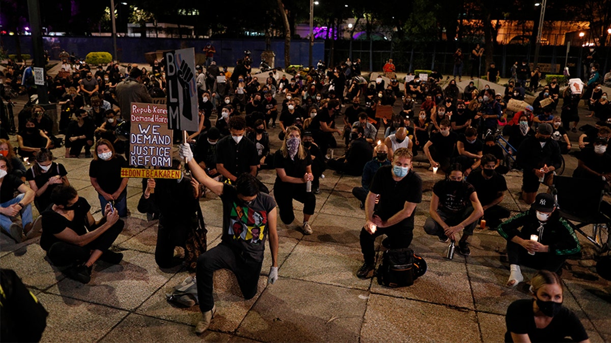 Protesters kneel outside the U.S. Embassy during a peaceful demonstration denouncing racism and calling for justice for victims of police violence, in Mexico City, Thursday, June 4, 2020. Americans, Mexicans and other foreign nationals gathered in Paseo de la Reforma Thursday night, chanting "Black lives matter" and kneeling silently as the names of victims of violence were read aloud, including that of George Floyd, a black American man who died after being restrained by Minneapolis police officers on May 25. (AP Photo/Rebecca Blackwell)