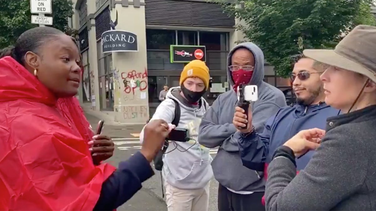 Christian Evangelist Bevelyn Beatty speaks to a group near the Seattle protest zone, denouncing Joe Biden and Black Lives Matter, saying only "Jesus saves."