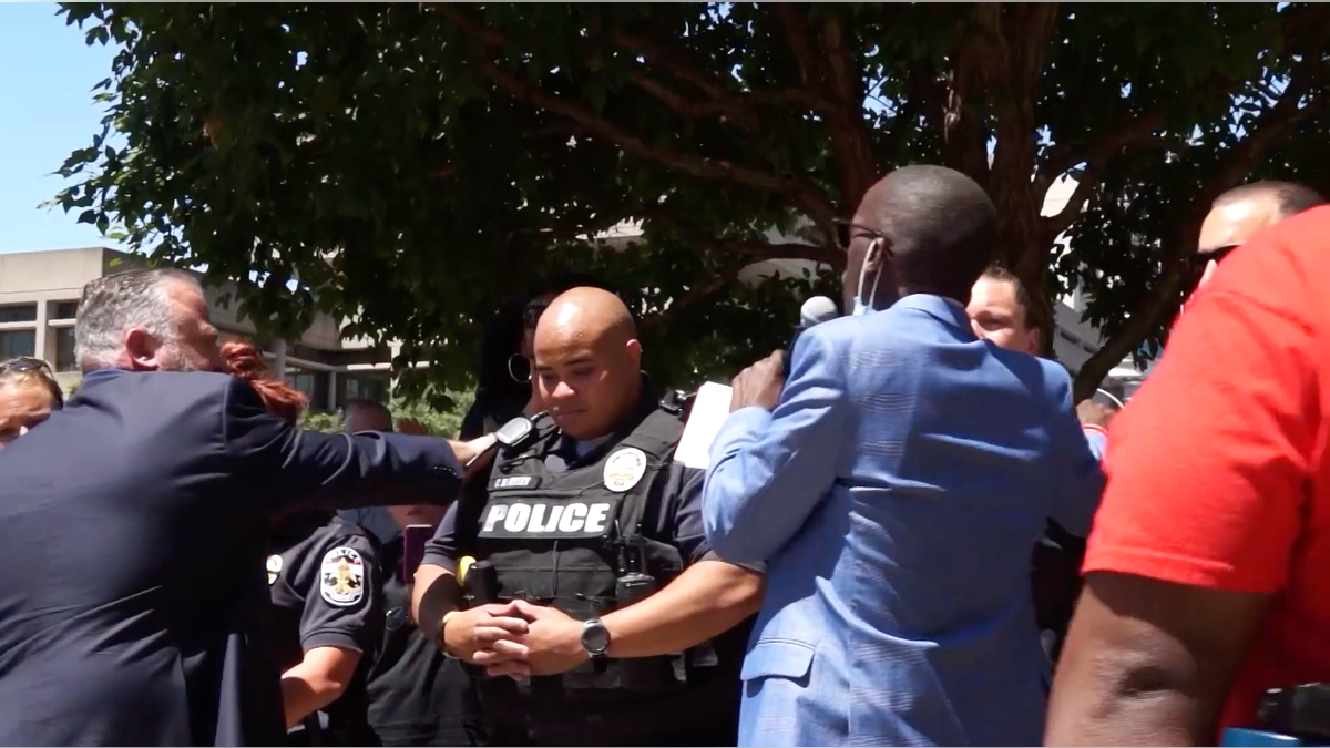 Pastor Brian Gibson prays over police officers with other faith leaders during a rally Tuesday in Louisville, Ky.
