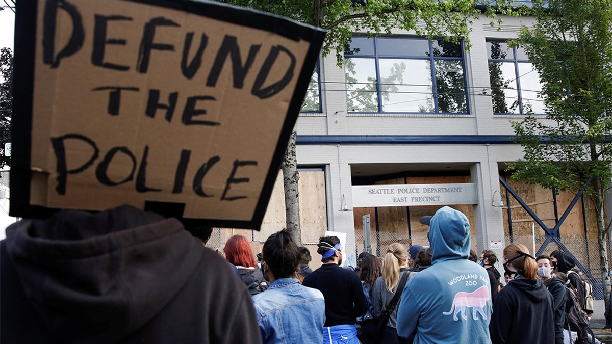 A protester holds a sign that reads "defund the police" after Seattle Police vacated the department's East Precinct and people continue to rally against racial inequality and the death in Minneapolis police custody of George Floyd, in Seattle, Washington, U.S. June 8, 2020. (REUTERS/Jason Redmond)?