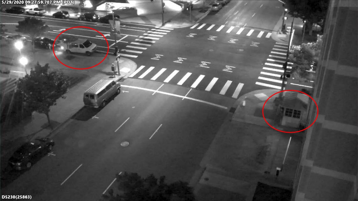 A still image taken from surveillance video outside the Oakland courhouse where David Patrick Underwood was abmushed and killed. The suspects' vehicle and the guard station have been circled in red. (DOJ)