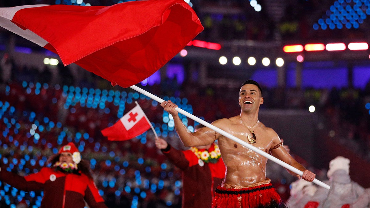 Peta Taufatofua carries a flag of Tonga during the opening ceremony of the 2018 Winter Olympics in Pyeongchang, South Korea, Friday, February 9, 2018.