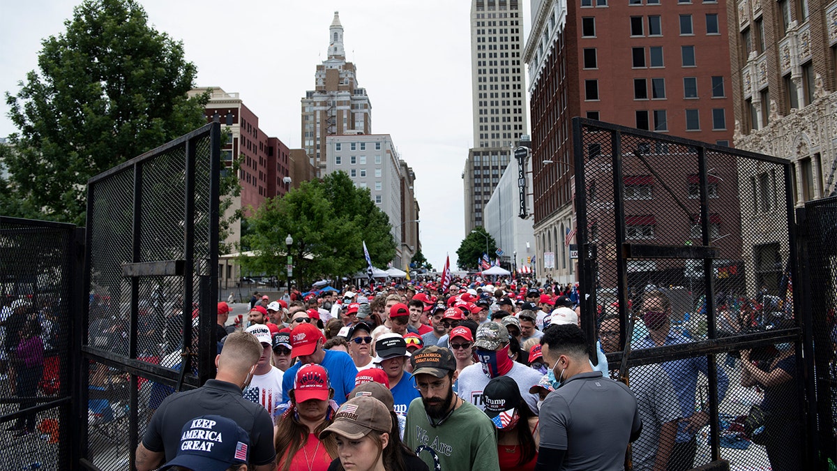 People wait at a security checkpoint to attend a rally with US President Donald Trump later in the evening at the BOK Center on June 20, 2020, in Tulsa, Oklahoma. - Hundreds of supporters lined up early for Donald Trump's first political rally in months, saying the risk of contracting COVID-19 in a big, packed arena would not keep them from hearing the president's campaign message. 