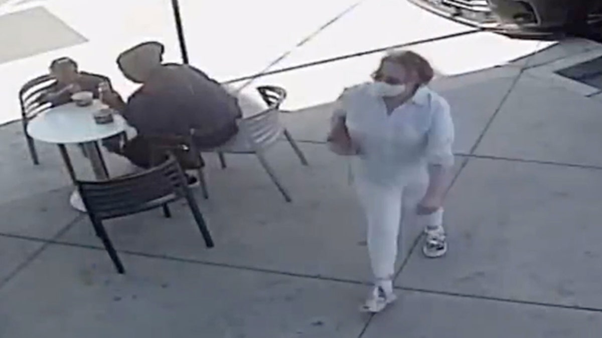 Police say a woman accused of coughing in a 1-year-old's face is wanted on assault charges. 