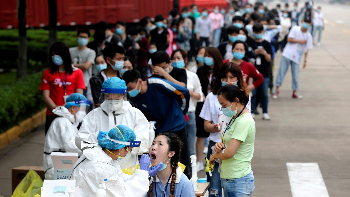 People line up for medical workers to take swabs for the coronavirus test at a large factory in Wuhan in central China's Hubei province on May 15.