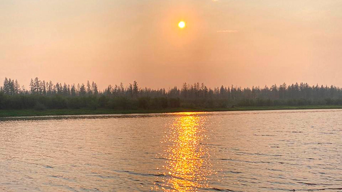 In this handout photo taken June 23, and provided by Olga Burtseva, a beach on the bank of Yana river is empty due to hot weather, during sunset outside Verkhoyansk, the Sakha Republic, about 2,900 miles northeast of Moscow, Russia.