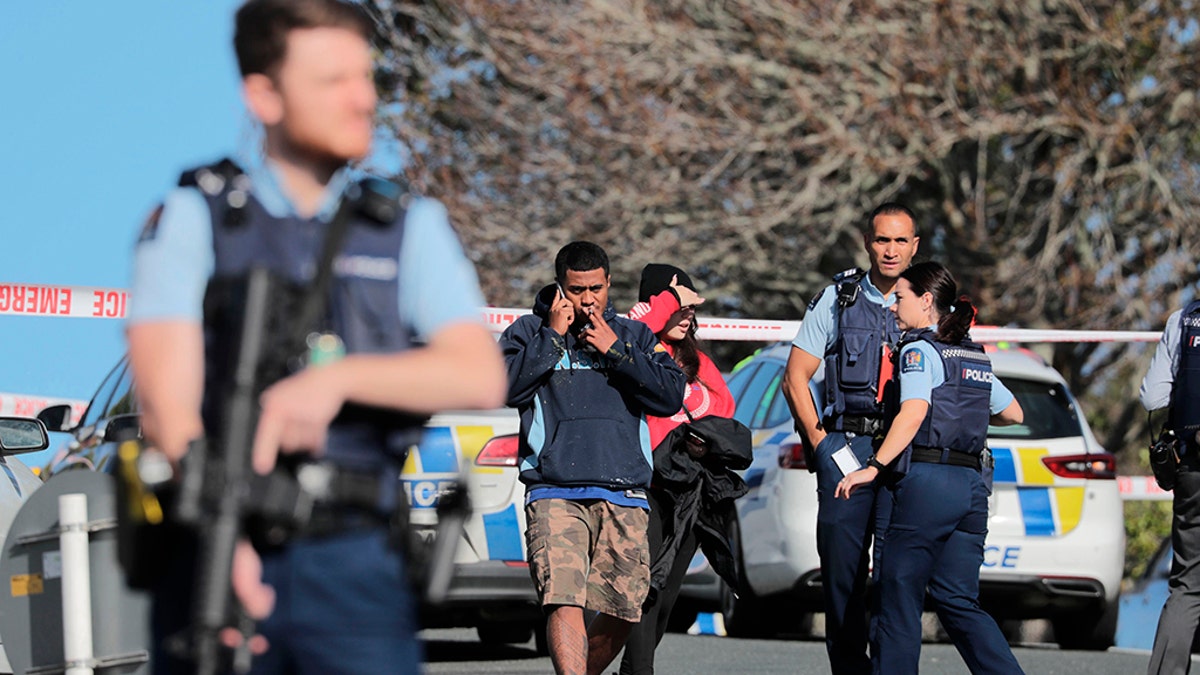 Armed police guard at the scene of a shooting incident following a routine traffic stop in Auckland, New Zealand, Friday, June 19, 2020. New Zealand police say a few officers have been shot and seriously injured and a suspect is on the run. (Michael Craig/New Zealand Herald via AP)