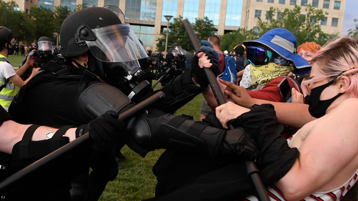 Aurora police officers clash with protesters with batons during the Elijah McClain protest at the Aurora Municipal Center on June 27, 2020. (Photo by Andy Cross/MediaNews Group/The Denver Post via Getty Images)