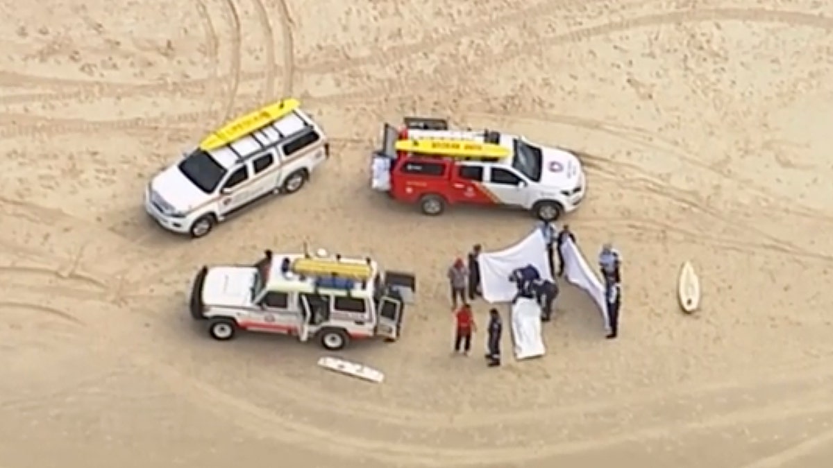 In this image made from aerial video, emergency personnel recover the body of a shark attack victim on the coast of Kingscliff, New South Wales, Australia, Sunday, June 7, 2020.
