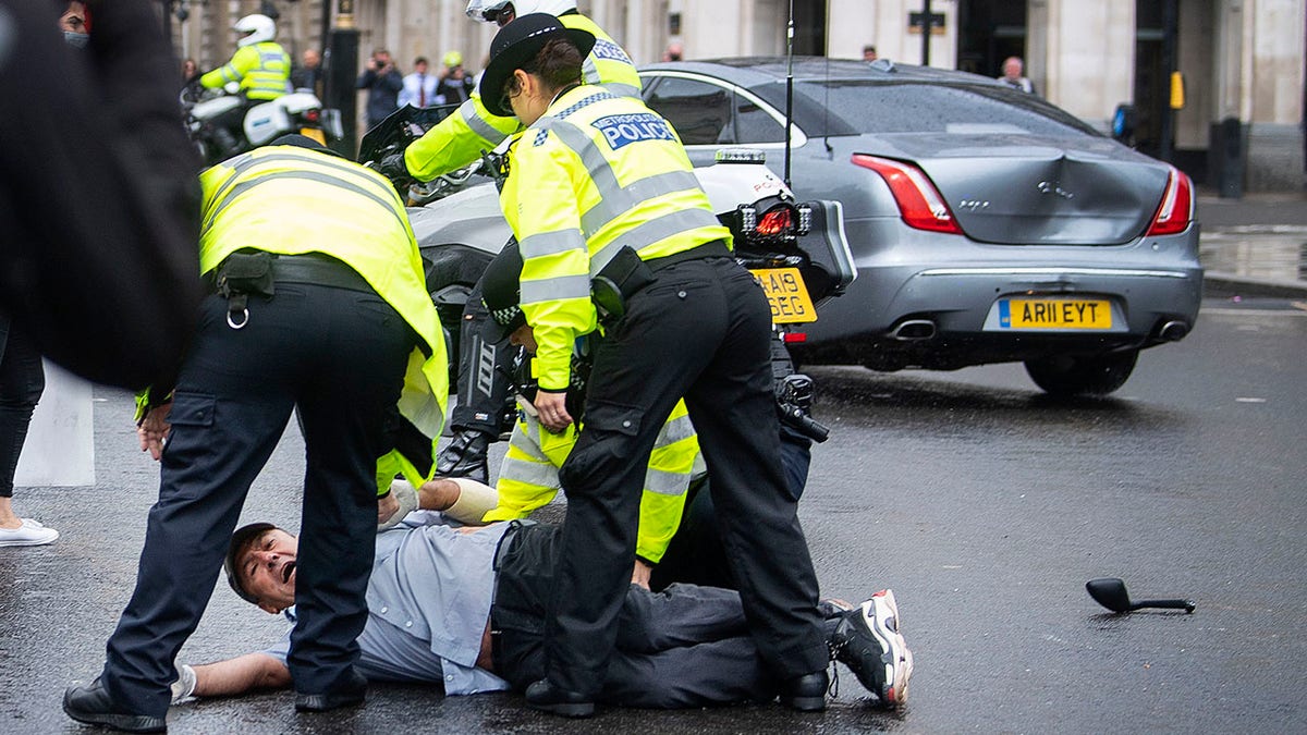 Police detained a man after he appeared to run in front of Johnson's car.  (Victoria Jones/PA via AP)