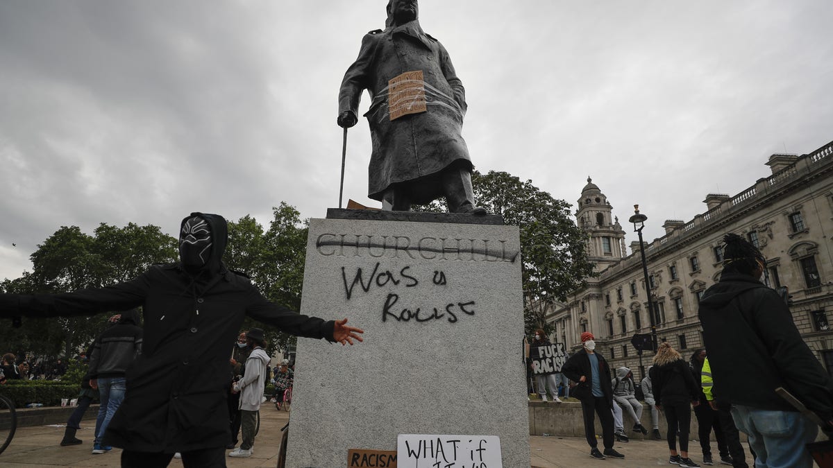 Protesters gather around a vandalized Winston Churchill statue in Parliament Square on Sunday. (AP)