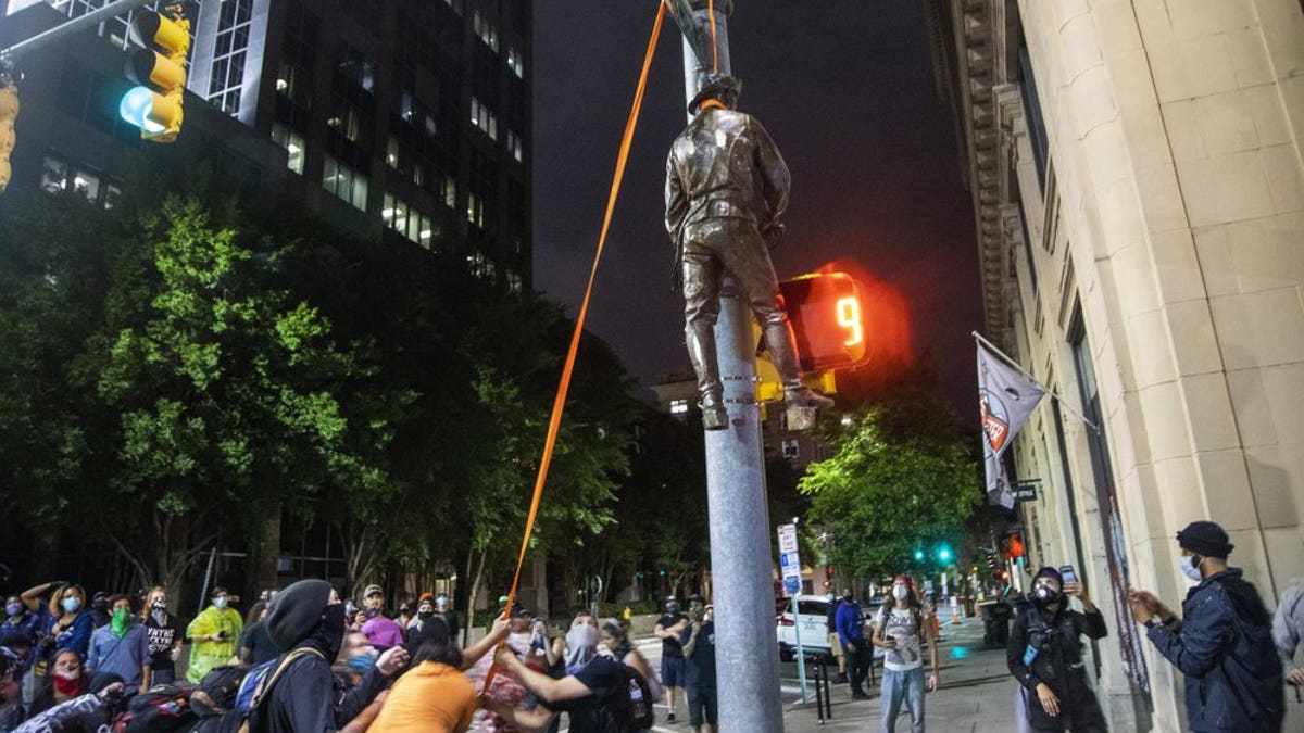 Protesters hang a figure pulled from the Confederate monument at the State Capitol at the intersection of Salisbury and Hargett Streets in Raleigh, N.C., on Juneteenth, Friday, June 19, 2020.
