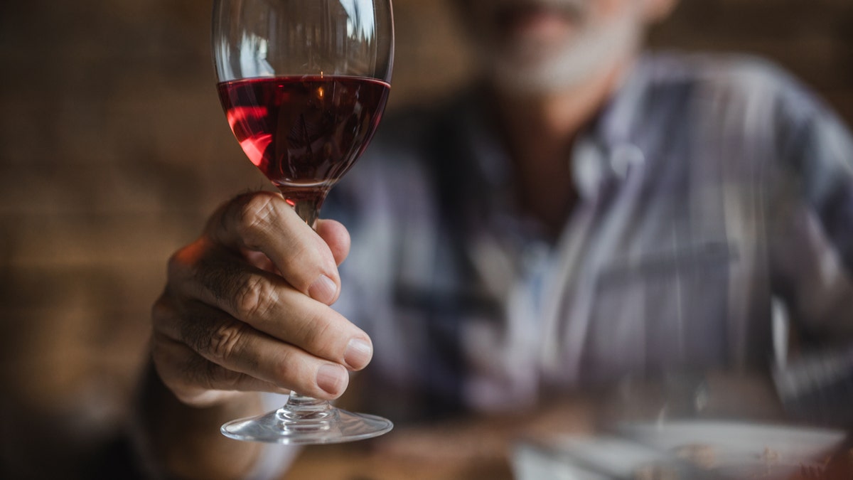 man hold glass of wine