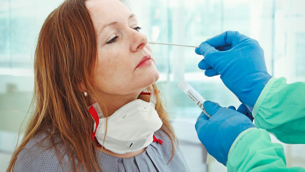 A medic takes a nasal swab from a patient for coronavirus testing. (iStock)