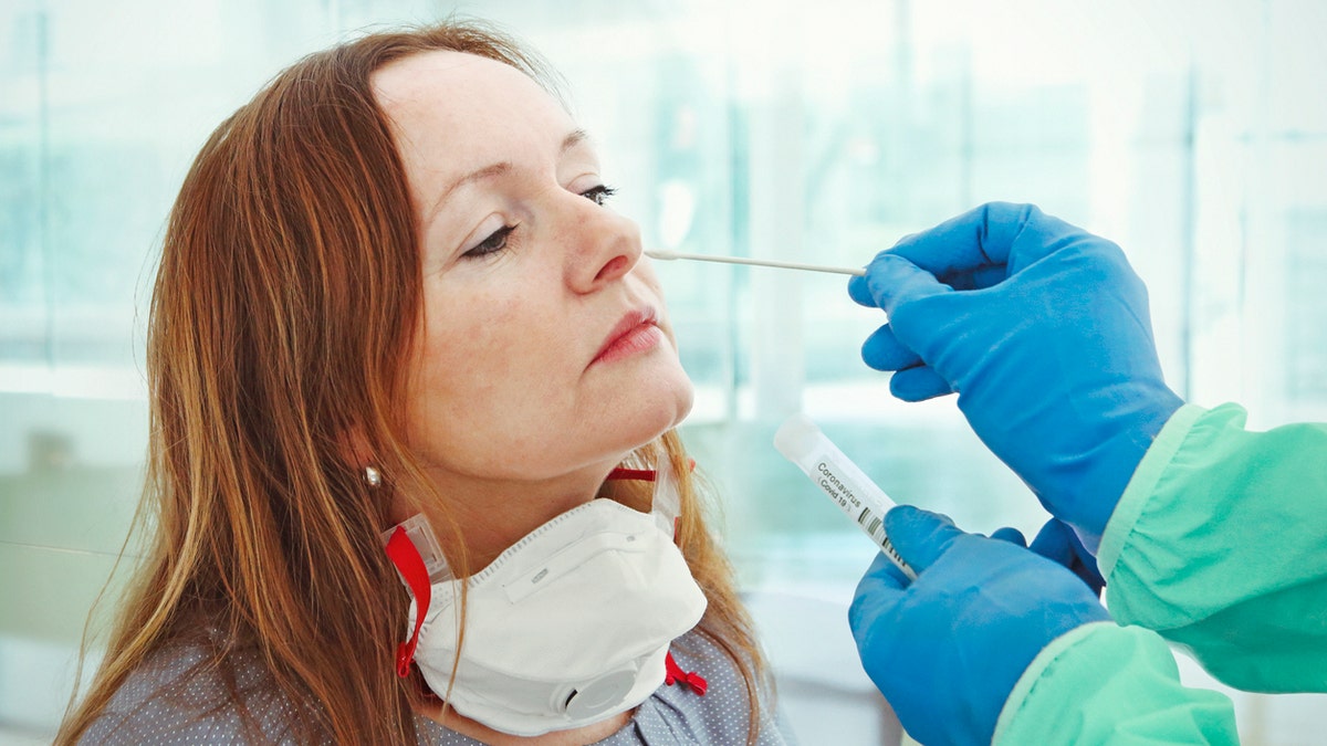 A medic takes a nasal swab from a patient for coronavirus testing. (iStock)
