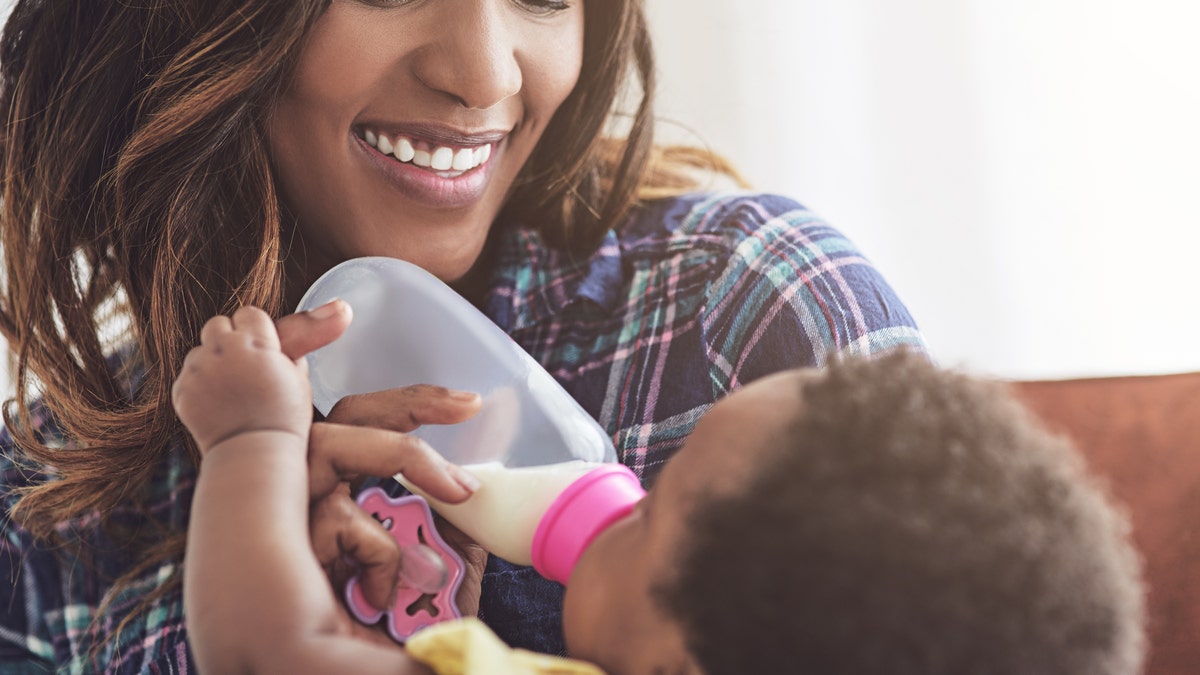 Mom feeds baby bottle