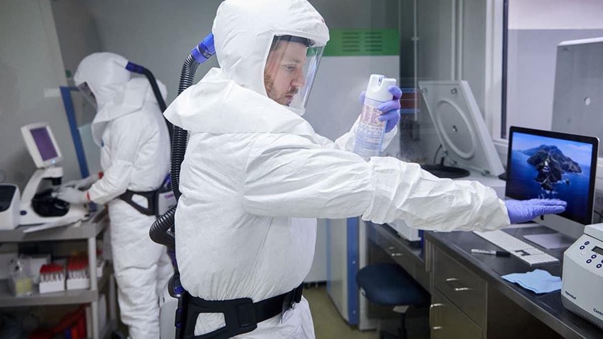 scientist in cleansuit works in lab